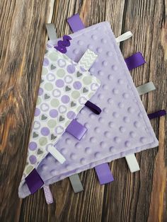 a purple and white triangle shaped object on top of a wooden table next to scissors