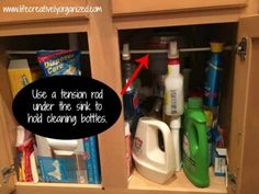 an organized kitchen cabinet with cleaning products and detergents in the bottom drawer, labeled use a tenon rod under the sink to ridding bottles