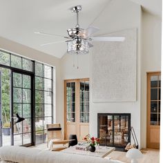 a living room with a couch, table and ceiling fan in it's center