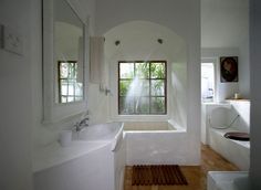 a bathroom with a tub, sink and large window in it's center wall