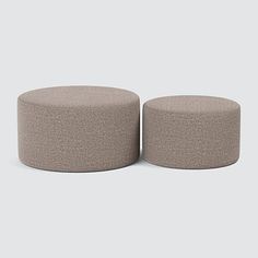 two round stools sitting next to each other on top of a gray flooring