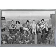 black and white photograph of people sitting on top of a building in new york city