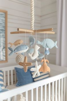 a baby crib with sea animals hanging from it's sides and on top of the bed