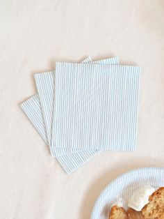 three pieces of cake on a plate with blue and white napkins next to it