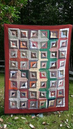 a quilted wall hanging in the grass