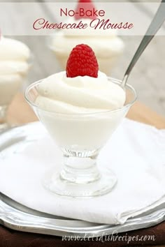 three small desserts with raspberries and whipped cream in glass dishes on a wooden table