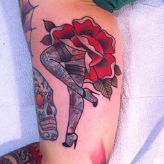 a woman's leg with tattoos and a rose on it