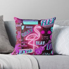 a pink flamingo pillow sitting on top of a couch