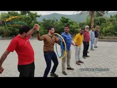 a group of men standing around each other with hoops in their hands and one man holding a frisbee up to his ear