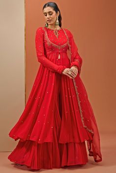 Designed to make a statement, this Red Embroidered Georgette Anarkali Sharara Set blends comfort and style, ensuring you stand out with sophistication. Crafted from luxurious georgette fabric, the flowing red anarkali features a graceful koti-style neckline embellished with intricate handwork, adding a touch of elegance to its traditional design. Paired with a matching sharara and a delicate organza dupatta with subtle embroidered edges. The vibrant red hue makes the Anarkali perfect for Home poojas, festive celebrations, weddings. Composition : Anarkali, Sharara Pants - Georgette, Dupatta - Organza and Lining - Semi crepe Care: Dry Clean Only and Vacuum Storage This product can be customized for sleeves, blouse length and neckline Delivery : 4-6 weeks as the product is hand crafted. Check Red Anarkali, Sharara Pants, Georgette Anarkali, Georgette Dupatta, Vacuum Storage, Sleeves Blouse, Sharara Set, Organza Dupatta, Georgette Fabric