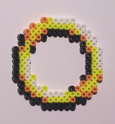 the letter o made out of beads on a white surface with an orange, yellow and black circle