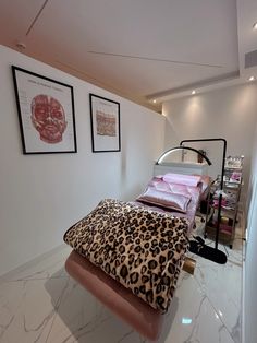 a leopard print bed in a bedroom with two framed pictures on the wall above it