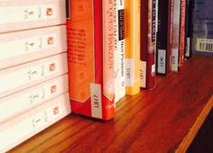 a row of books sitting on top of a wooden shelf