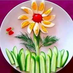 a white plate topped with cucumbers and sliced up flowers on top of each other