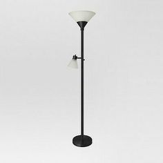 a black floor lamp with two white lamps on it