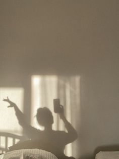 the shadow of a person's head on a bed in front of a window