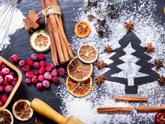 an assortment of fruits and spices on a black surface with the shape of a christmas tree