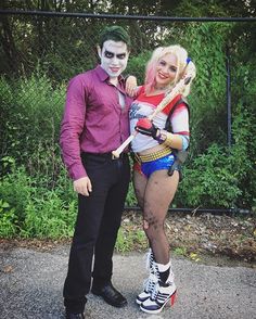 two people dressed up as the joker and harley in front of a chain link fence