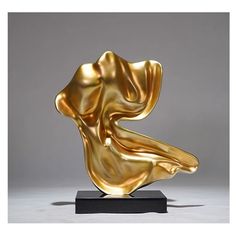 a gold sculpture sitting on top of a black base