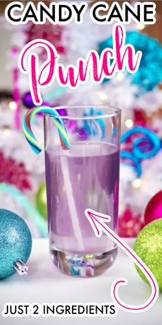 a glass filled with purple liquid next to christmas ornaments