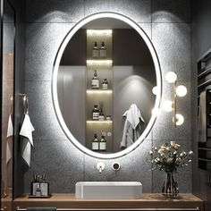 a bathroom with a sink, mirror and shelves on the wall above it is lit by lights