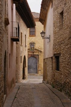 an alley way with stone buildings and cobblestones