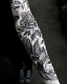 a woman's leg with black and white flowers on it