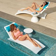 two women lounging on lounge chairs next to a swimming pool with an inflatable sunbather