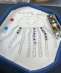 a child's drawing on the floor with beads and candy in front of it