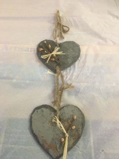 two heart shaped slates tied together with twine and some other things hanging from them