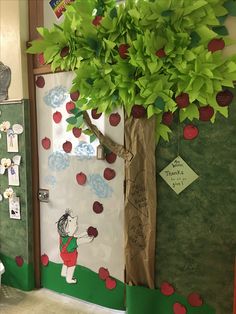 a classroom door decorated with apples and a tree