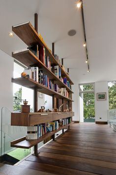 a bookshelf with many books on it in the middle of a wooden floor