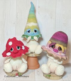 three crocheted little gnomes sitting on top of a pot with one wearing a hat