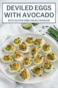 deviled eggs with avocado on a white plate