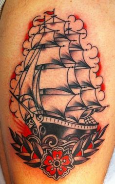 a tattoo on the leg of a man with a ship in it's center