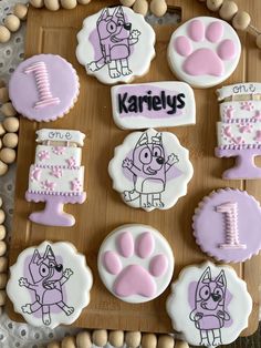 decorated cookies on a wooden tray with name and dog's paw designs in the middle