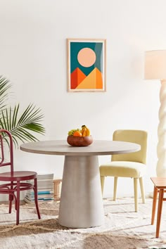 a dining room table with chairs and a painting on the wall in the back ground