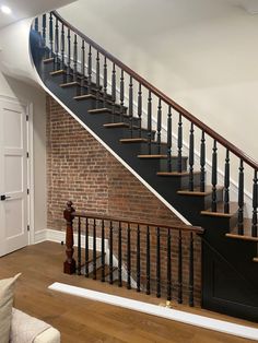 an empty room with a stair case next to a brick wall