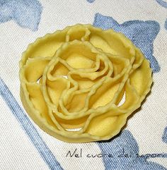 a small yellow flower sitting on top of a blue and white table cloth