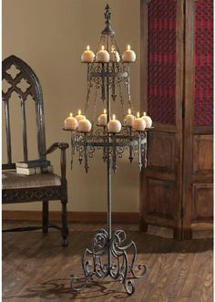 a candle holder with candles on it in front of a chair and wooden flooring