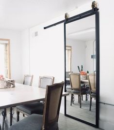 a dining room table with chairs and a large mirror