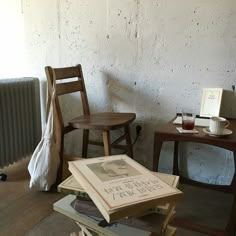 a stack of books sitting on top of a wooden table next to a radiator