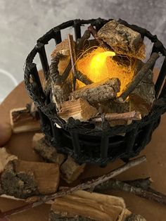 a basket filled with lots of wood next to a pile of firewood on top of a table