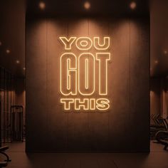 a neon sign that says you got this in front of a wall with gym equipment