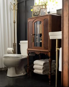 a bathroom with a toilet, sink and bookcase in the corner next to it