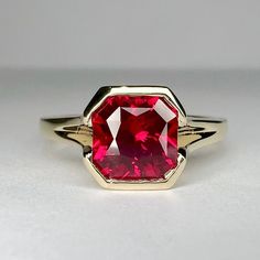 "The ring pictured is lab created ruby #7173 Also shown in 14k white gold  -Approximate total carat weight:  approx. 1.75ctw diamond equivalent  -Center Stone Size:  7x7mm - approx. 1.75ct diamond equivalent -Center Stone Shape: radiant cut -Gem Type:  lab created ruby -Stone Clarity: VS2 -Stone Color: Red -Moh's Scale: 8.5 hardness -Metal Type and Purity: 14k yellow gold -Setting: Half Bezel  -Stock Ring Size: 6 -Country of Manufacturing:  USA (Michigan) For customization please contact us. If Cushion Ruby Ring, Ruby Bezel Ring, Ruby Engagement Rings, Engagement Rings Solitaire, Setting Engagement Ring, Rings Solitaire, Gold For Women, Half Bezel, Ruby Ring Gold