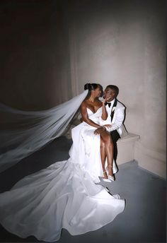 a bride and groom are sitting on a bench