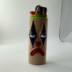 a lighter with a face painted on it