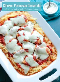 chicken parmesan casserole in a white dish with sauce and cheese on top