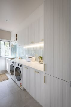 a washer and dryer in a white laundry room